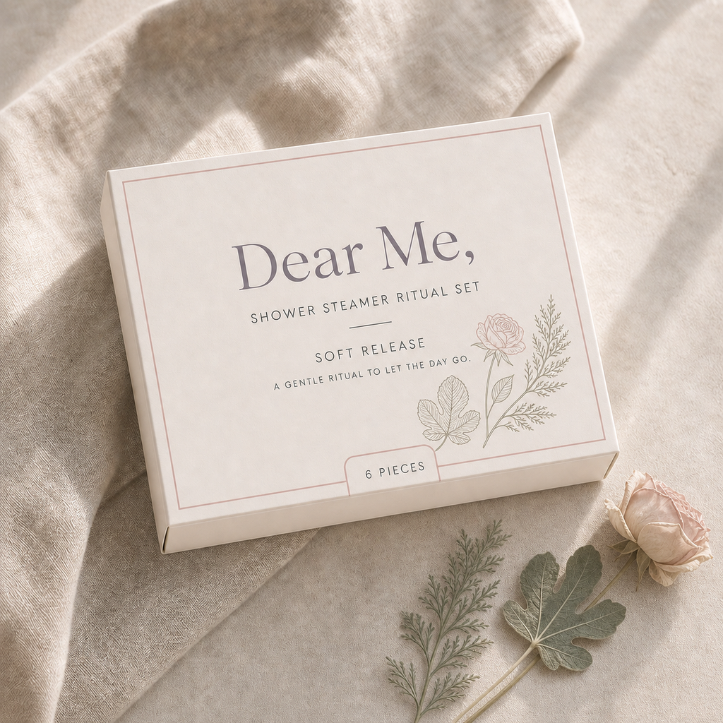 A quiet luxury product hero image showing the SOFT RELEASE six-piece shower steamer gift set in Dear Me, packaging with cedar, fig and rose-inspired botanical details.