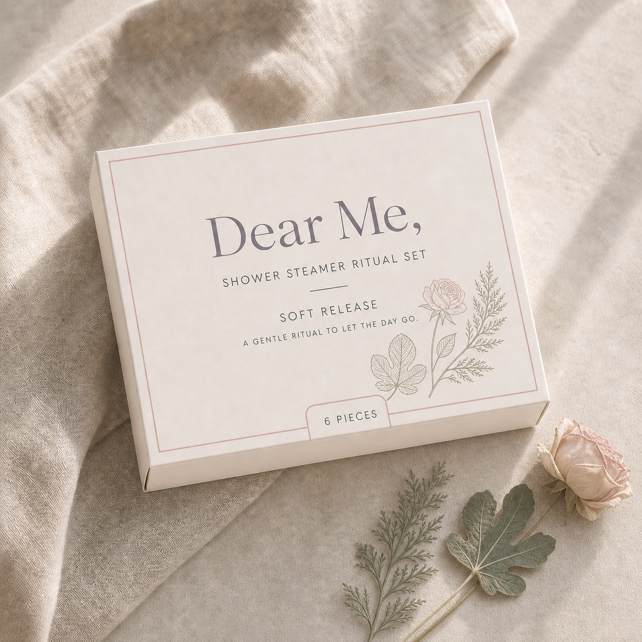 A quiet luxury product hero image showing the SOFT RELEASE six-piece shower steamer gift set in Dear Me, packaging with cedar, fig and rose-inspired botanical details.