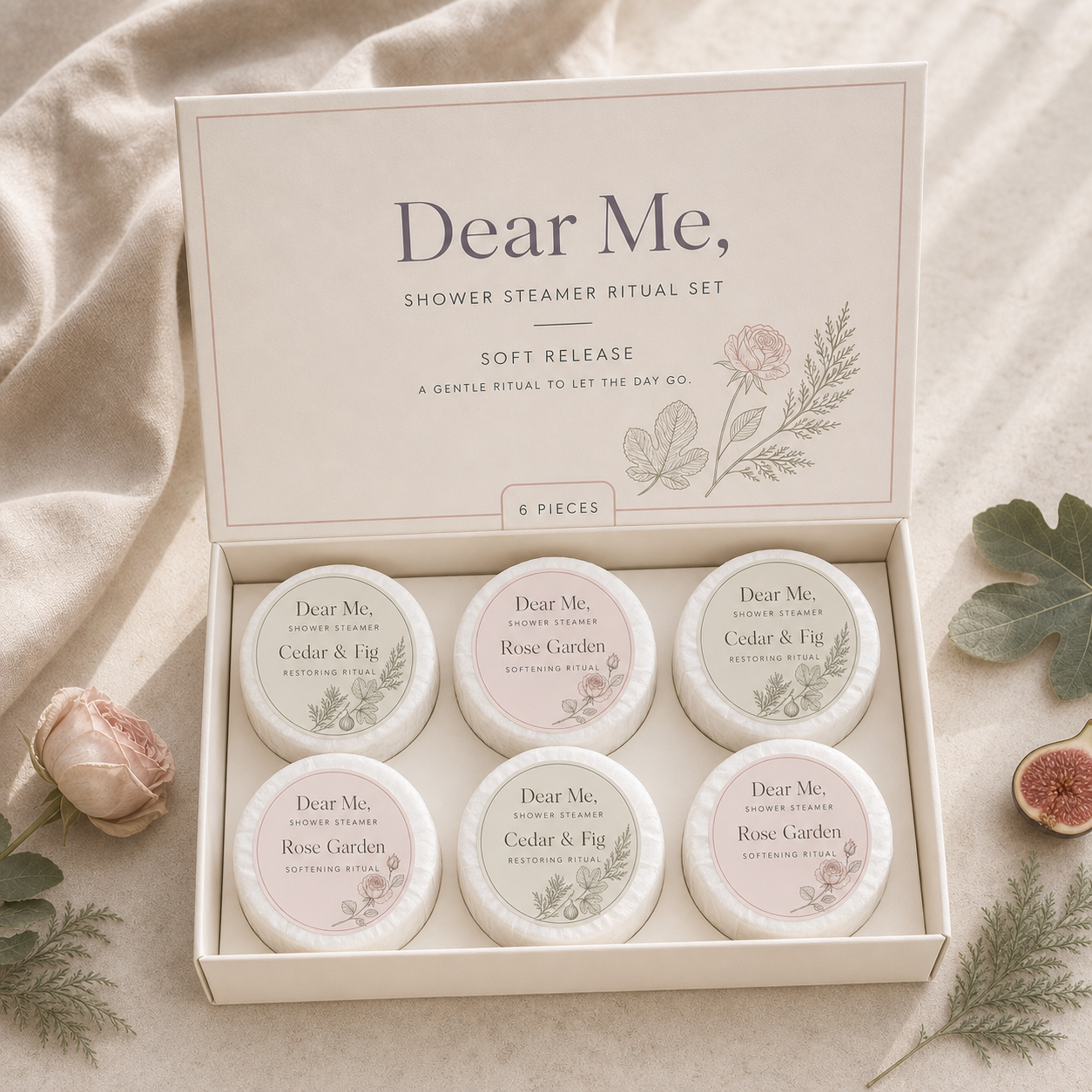 A quiet luxury product hero image showing the SOFT RELEASE six-piece shower steamer gift set in Dear Me, packaging with cedar, fig and rose-inspired botanical details.